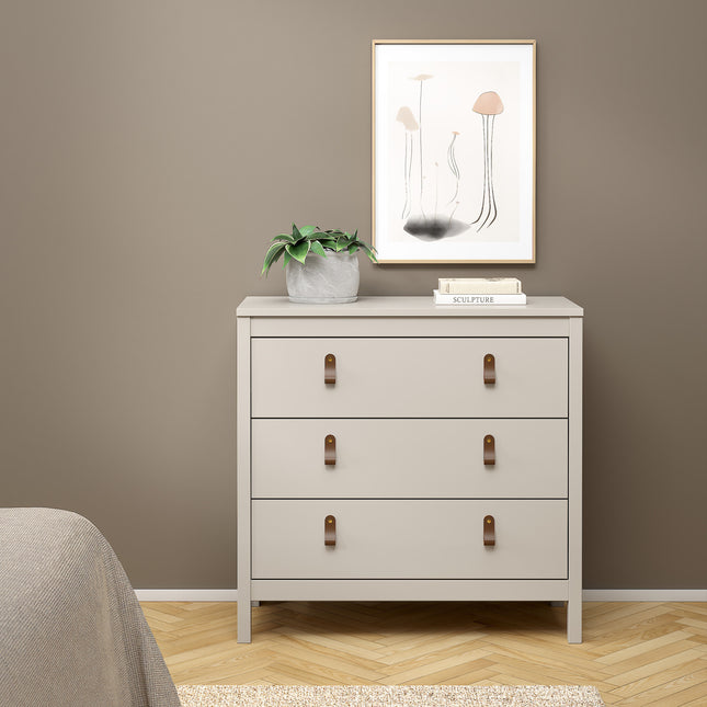 Three-drawer chest in light grey with leather strap handles, topped with a potted plant and framed artwork on the wall
