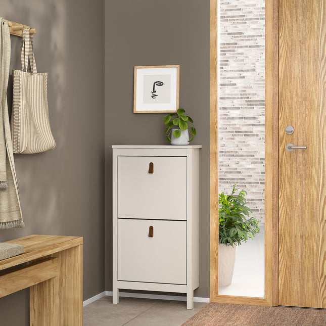 Cabinet with two flap doors, featuring brown leather handles, in a light grey finish, placed against a neutral wall
