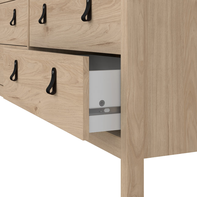 Light wood dresser with four large drawers, featuring black metal handles and a partially open drawer revealing storage