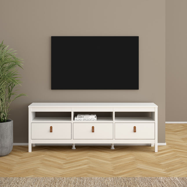 Low TV unit with three drawers and open shelving, finished in white with wooden handles, set against a neutral wall