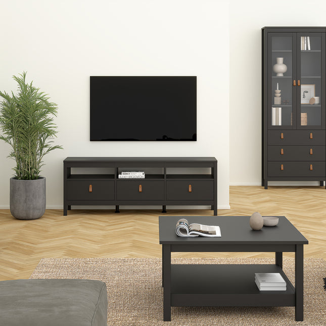 Low TV unit with three drawers and open shelves, finished in black, set against a light wall and wooden floor