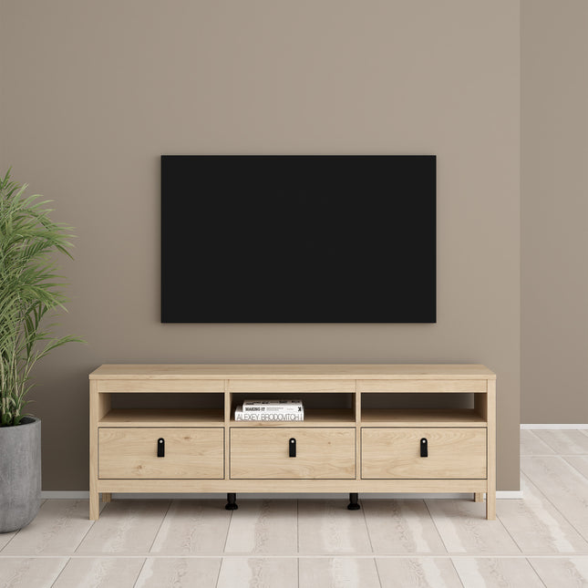 Low wooden unit with three drawers and open shelves, featuring black handles, set against a neutral wall