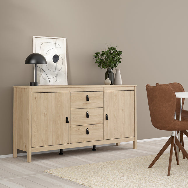 Light wooden sideboard with two doors and three drawers, featuring black handles, against a beige wall