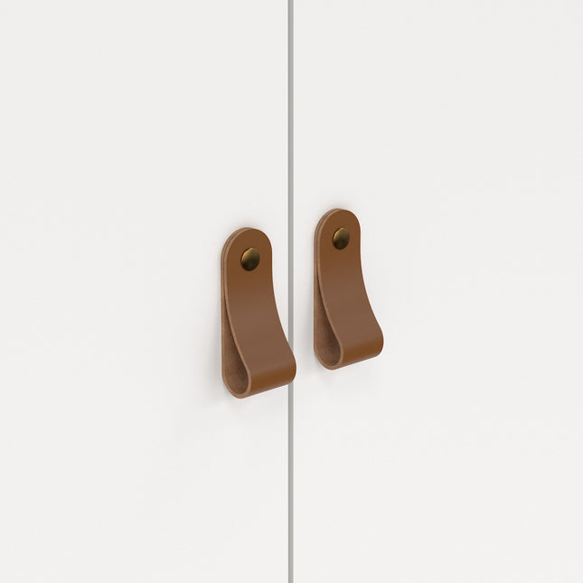 Two brown leather handles on a white wardrobe door, featuring a curved design and a circular mounting hole