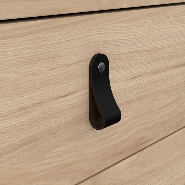 Black leather handle on a light wood drawer front, featuring a smooth finish and subtle grain texture
