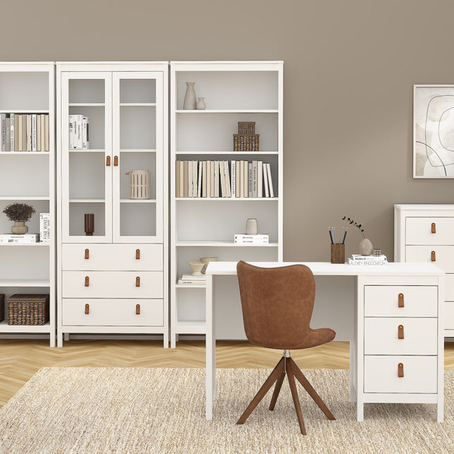 White bookcase with glass doors and wooden handles, alongside a white desk with drawers and a brown upholstered chair