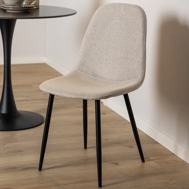 Dining chair with a curved backrest and upholstered seat in beige fabric, supported by four black metal legs
