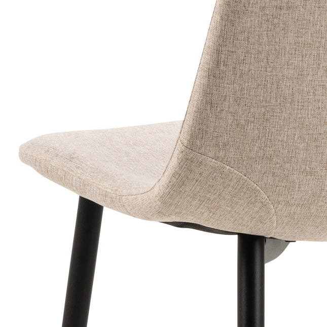 Dining chair with a curved backrest and tapered black legs, upholstered in a textured beige fabric