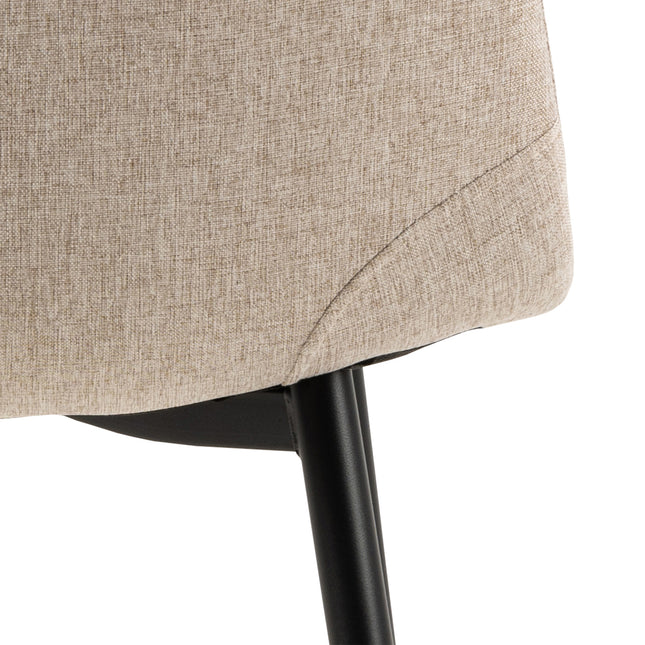 Beige upholstered chair with a curved backrest and black metal legs