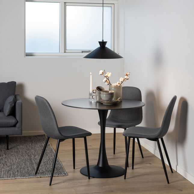 Round dining table with a black base and grey top, surrounded by three matching chairs with tapered legs