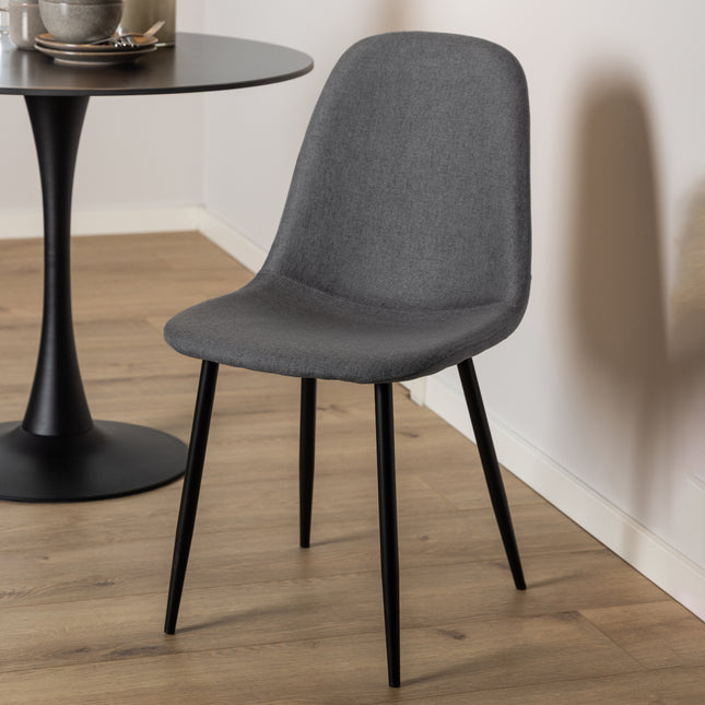 Dining chair with a curved backrest and tapered black legs, upholstered in light grey fabric