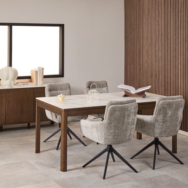 Rectangular dining table with a cream ceramic top and wooden legs, surrounded by four upholstered chairs with swivel bases