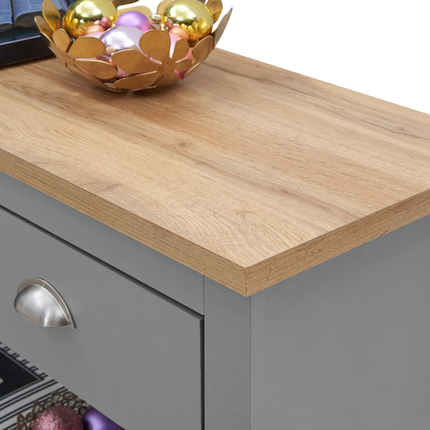 Grey console table with a smooth wooden top and a single drawer featuring a silver handle. Decorative bowl with colourful