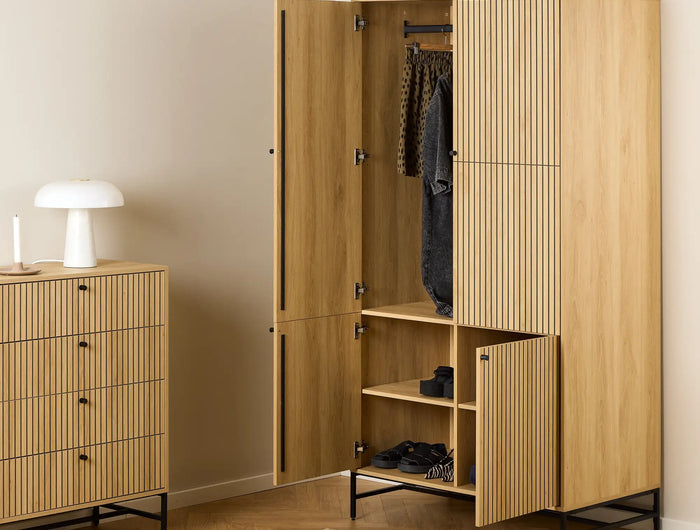 Light wood-finish wardrobe with vertical slat panels and black metal frame.