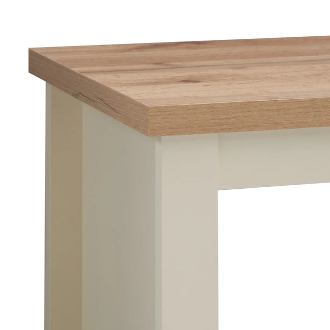 Close-up of oak-effect tabletop corner with cream-painted leg beneath