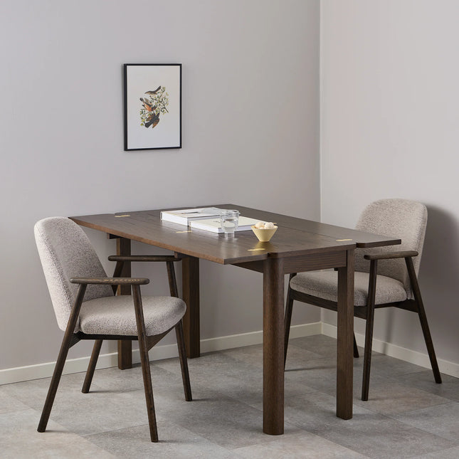 Leo dining chair close-up of beige Monza fabric upholstery and dark wood armrest and legs