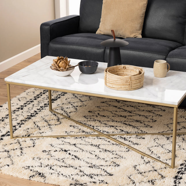 Alisma coffee table close-up of gold metal cross-frame legs and white marble-effect top edge