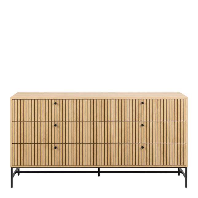 Close-up of oak-effect slatted drawer fronts with round black knobs and black metal legs