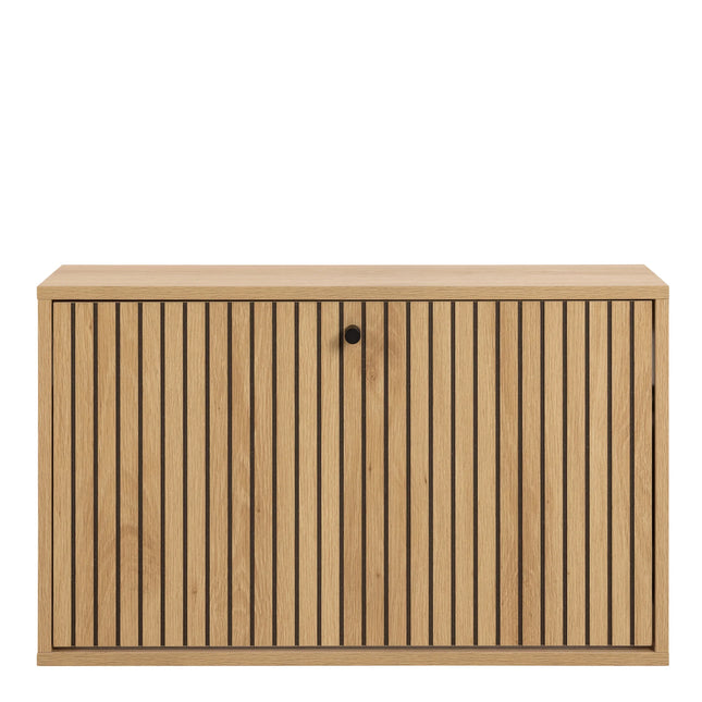 Close-up of oak-effect shoe cabinet door with vertical slatted grooves and round black knob