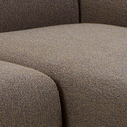 Bouclé upholstery close-up in warm taupe showing textured looped fabric and seam detail