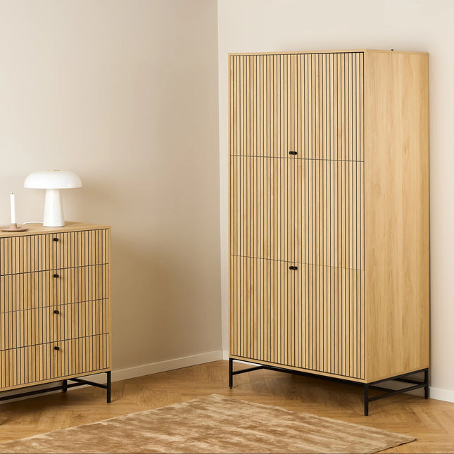 Close-up of Albany wardrobe and matching chest showing vertical slatted oak-effect doors and black metal legs
